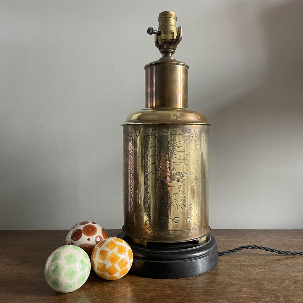 A large Brass table lamp. Decorated in a chased style and mounted upon a turned and weighted black wooden base. Wired for electricity with a switchable screw thread lamp fitting, three core black cloth covered cable new plug and pat tested - SHOP NOW - www.intovintage.co.uk