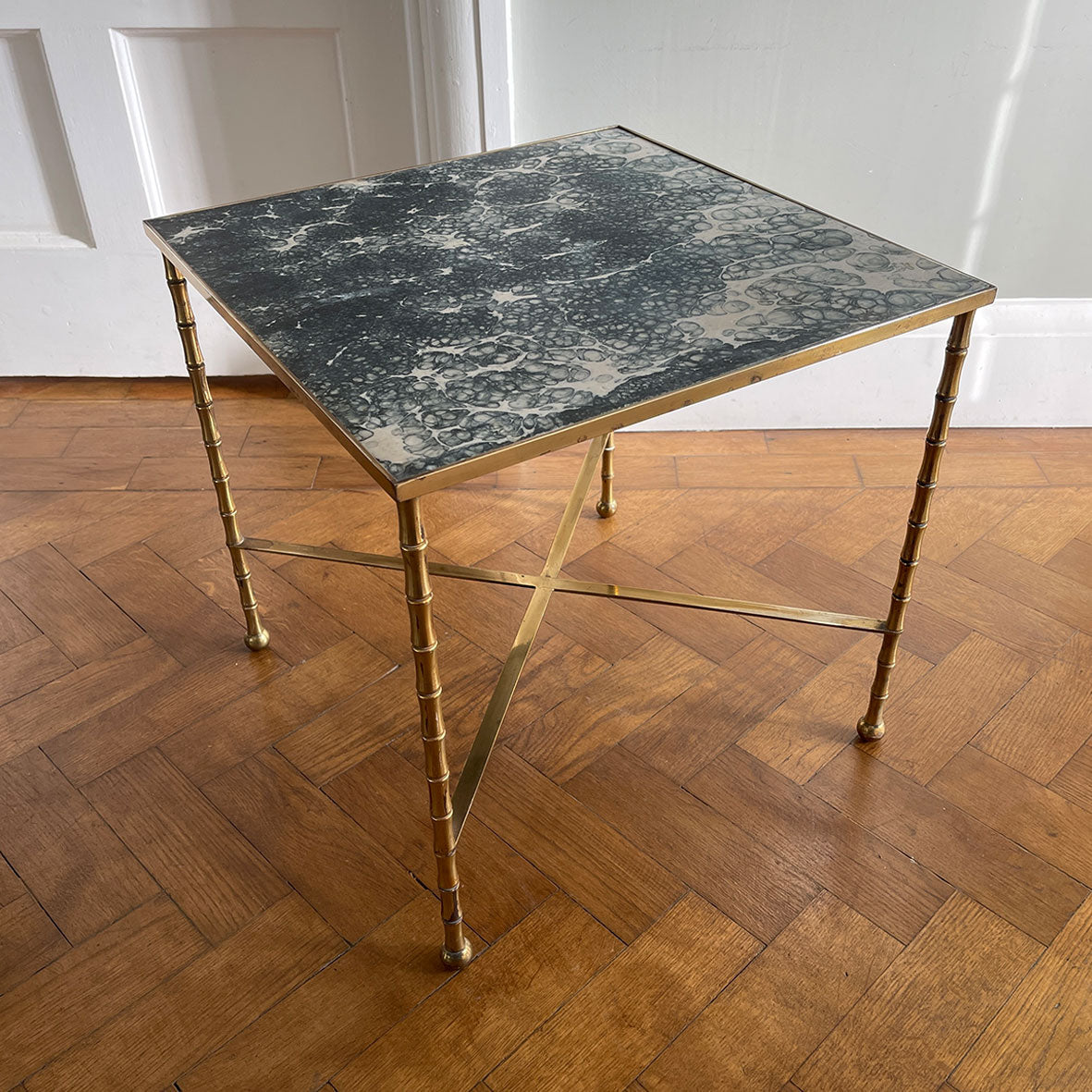 A super smart, gilded brass, Hollywood Regency style lounge side table. Faux Bamboo design to the legs held sturdy by a brass cross stretcher. The brass lipped top sees a beautiful faux marble style laminate. Tres chic! - SHOP NOW - www.intovintage.co.uk