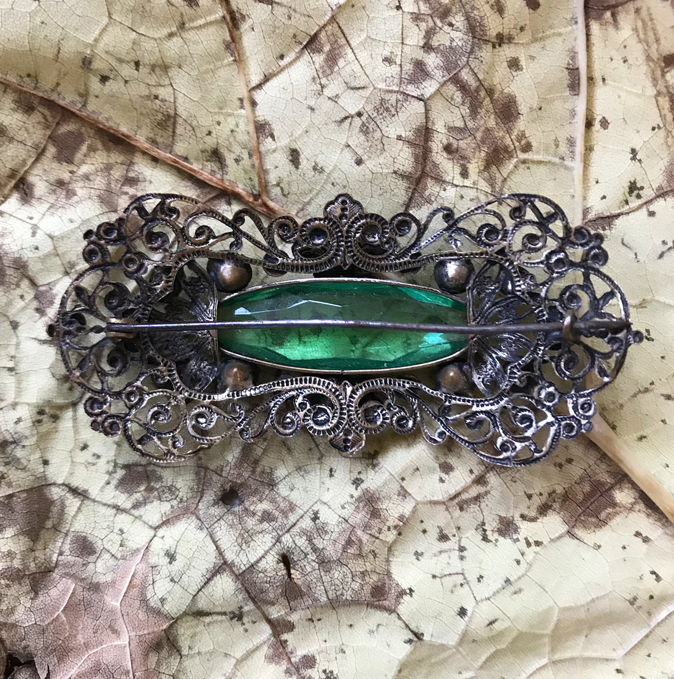 Excellent quality Edwardian Brooch with intricate design detail. Numerous faceted glass emeralds surrounding one larger green glass gem. - SHOP NOW -  www.intovintage.co.uk