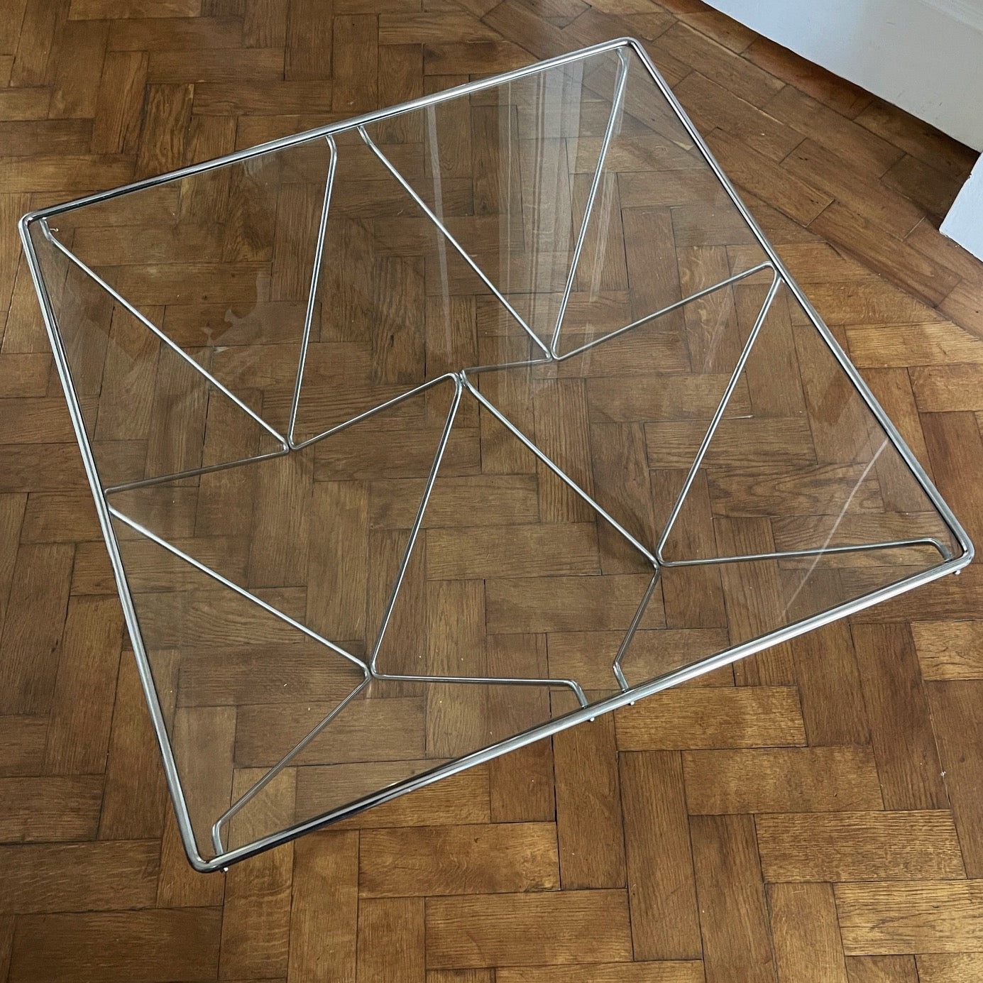 A stylish modernistic chromed square vintage coffee table in the Style of Paolo Piva circa 1980, Italy.Simple and elegant in form, the frame is made of chromed steel shaped connected triangles. Clear glass top - SHOP NOW - www.intovintage.co.uk