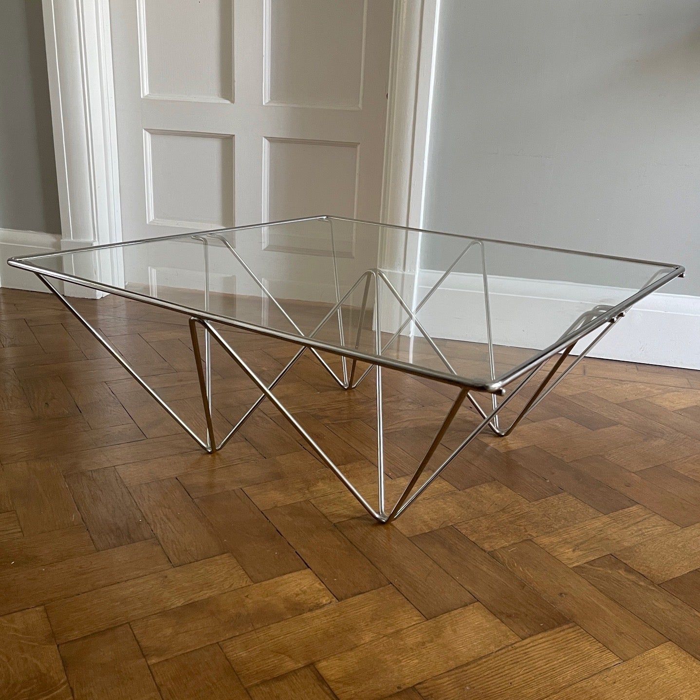 A stylish modernistic chromed square vintage coffee table in the Style of Paolo Piva circa 1980, Italy.Simple and elegant in form, the frame is made of chromed steel shaped connected triangles. Clear glass top - SHOP NOW - www.intovintage.co.uk