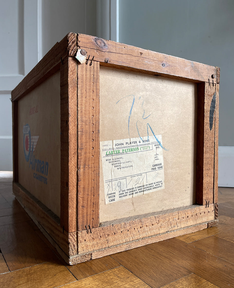 A 1950s Players Airman's Cigarettes Delivery Crate in excellent condition. With the Player's Airman logo to the main sides panels and the Player's Navy Cut logo on one of the end panels. The opposite end has the original delivery label still stuck to it. Great for general storage or a cool log box for beside the fire - SHOP NOW - www.intovintage.co.uk