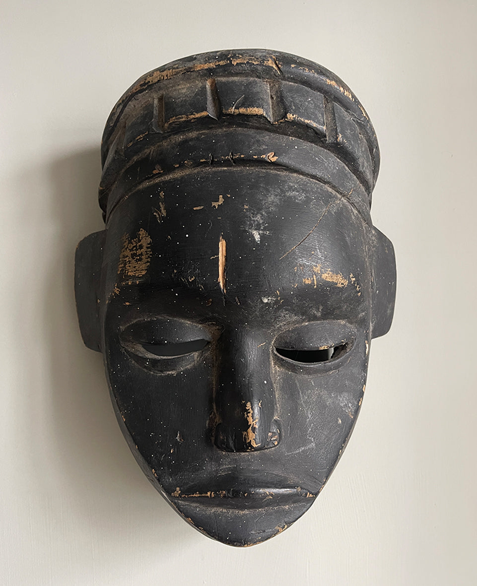 A good looking Tribal Mask. The face has a beautiful simplicity to it with slit eyes and a prominent nose. A stylised crown sits atop of the head. finely carved with a black painted finish - SHOP NOW - www.intovintage.co.uk