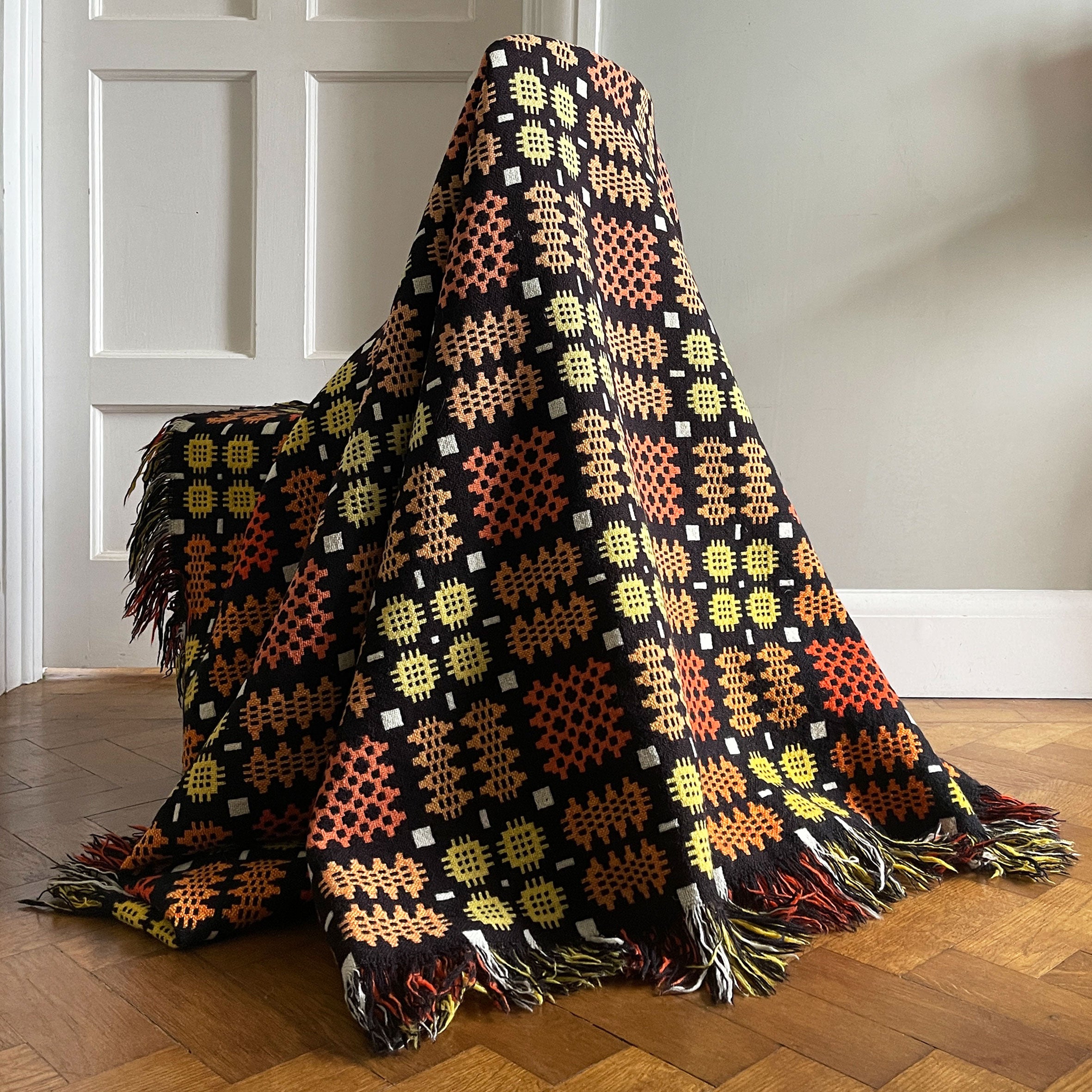 A pure wool Welsh Tapestry blanket in Black, Orange, Red, White and Yellow - SHOP NOW - www.intovintage.co.uk