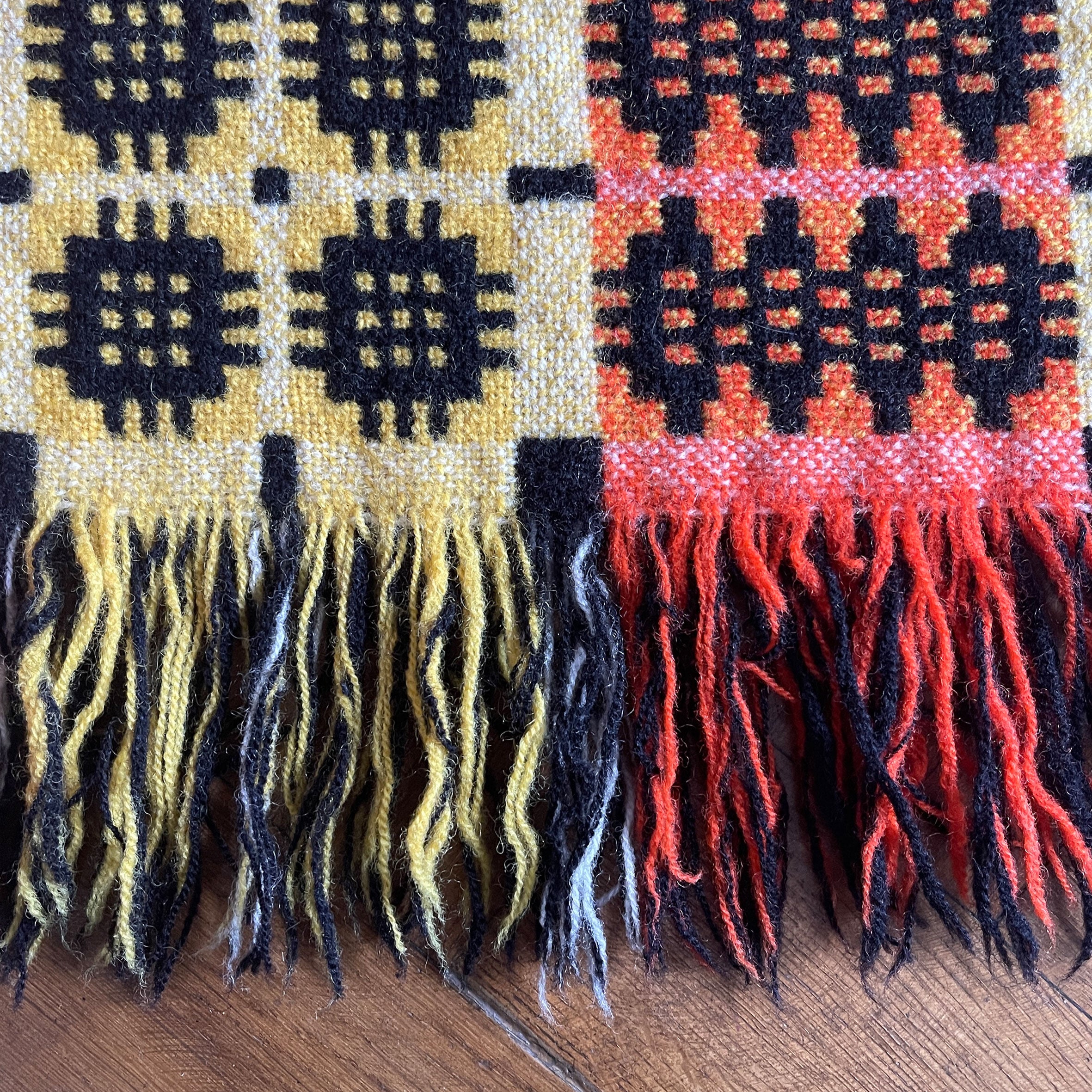 A pure wool Welsh Tapestry blanket in Black, Orange, Red, White and Yellow - SHOP NOW - www.intovintage.co.uk