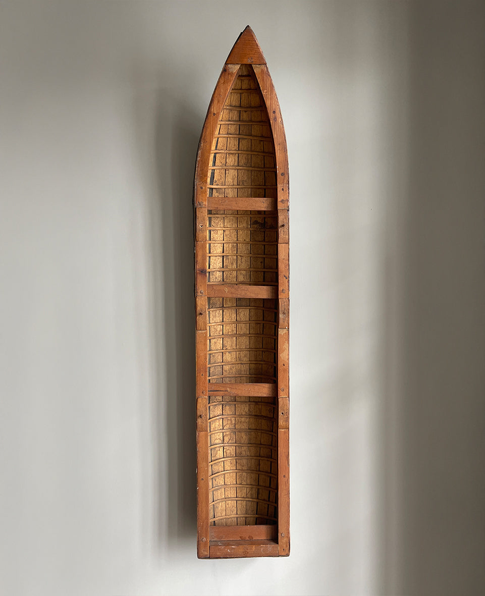 A vintage scratch built long boat. Of a ribbed and planked construction with three seats and a painted canvas hull. The boat has an added string so that it can be hung on the wall as a piece of art. A fascinating item - SHOP NOW - www.intovintage.co.uk