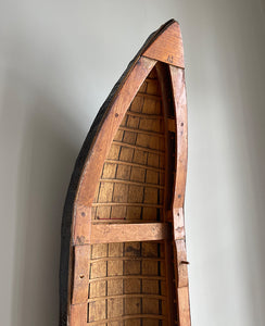 A vintage scratch built long boat. Of a ribbed and planked construction with three seats and a painted canvas hull. The boat has an added string so that it can be hung on the wall as a piece of art. A fascinating item - SHOP NOW - www.intovintage.co.uk
