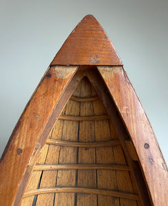 A vintage scratch built long boat. Of a ribbed and planked construction with three seats and a painted canvas hull. The boat has an added string so that it can be hung on the wall as a piece of art. A fascinating item - SHOP NOW - www.intovintage.co.uk