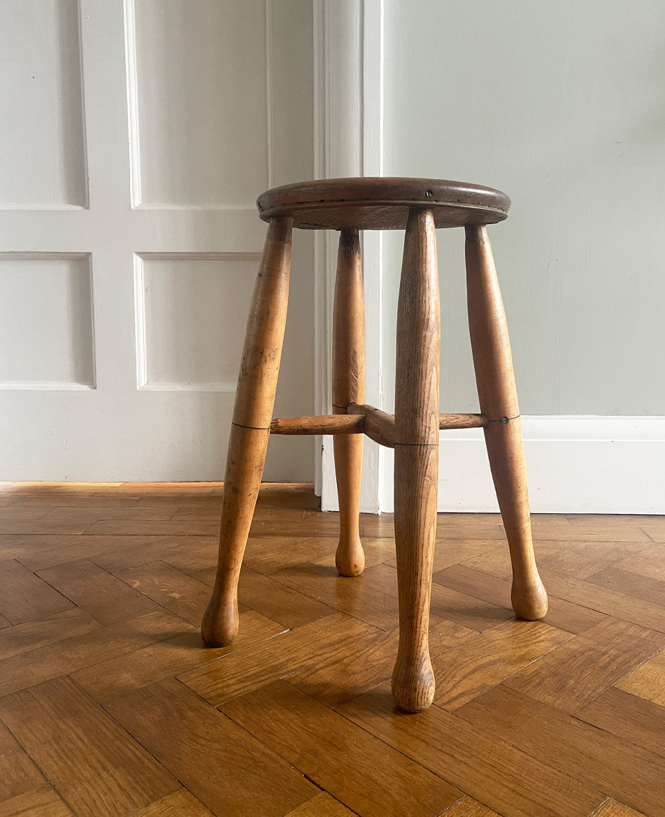 A Good looking Vintage Elm Stool. Fantastic age related wear and patina with a beautiful warm honey colour. There has been some historical repairs yet still totally solid. The seat section has a wonderful dip to it, nicely turned legs and a superb centre joint on the cross stretchers. Underneath bears the stamp 'IHS', so the stool has likely come from a church - SHOP NOW - www.intovintage.co.uk