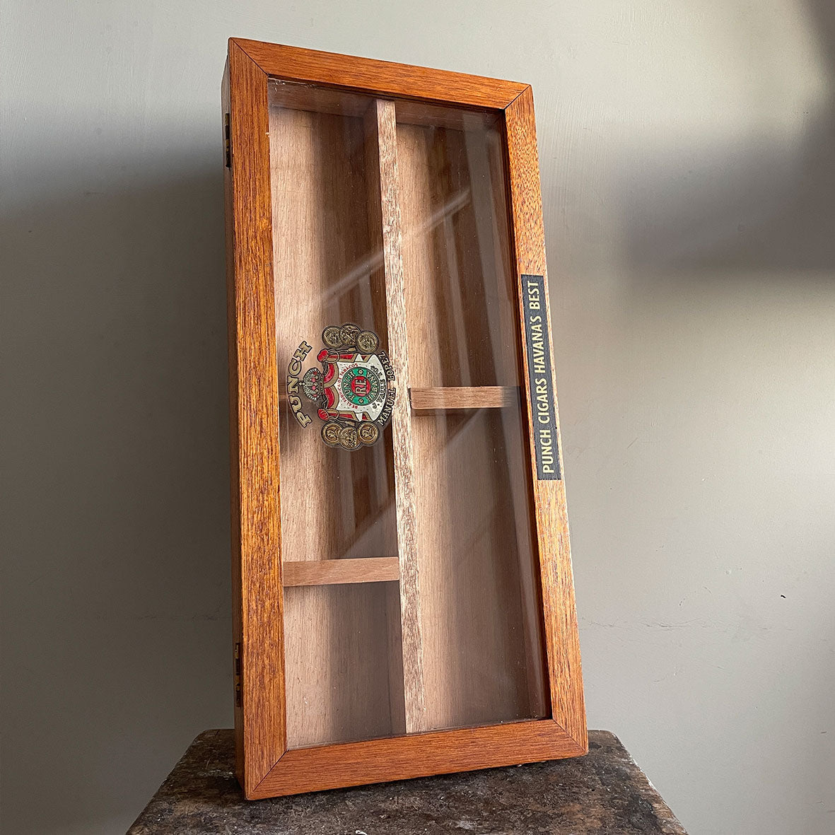 A Vintage mahogany Punch Cigar Display Case with 4 compartments. The glass hinged lid displays the Manuel Lopez Punch crest whilst the frame shows the legend 'Punch Cigars Havana's Best' - SHOP NOW - www.intovintage.co.uk