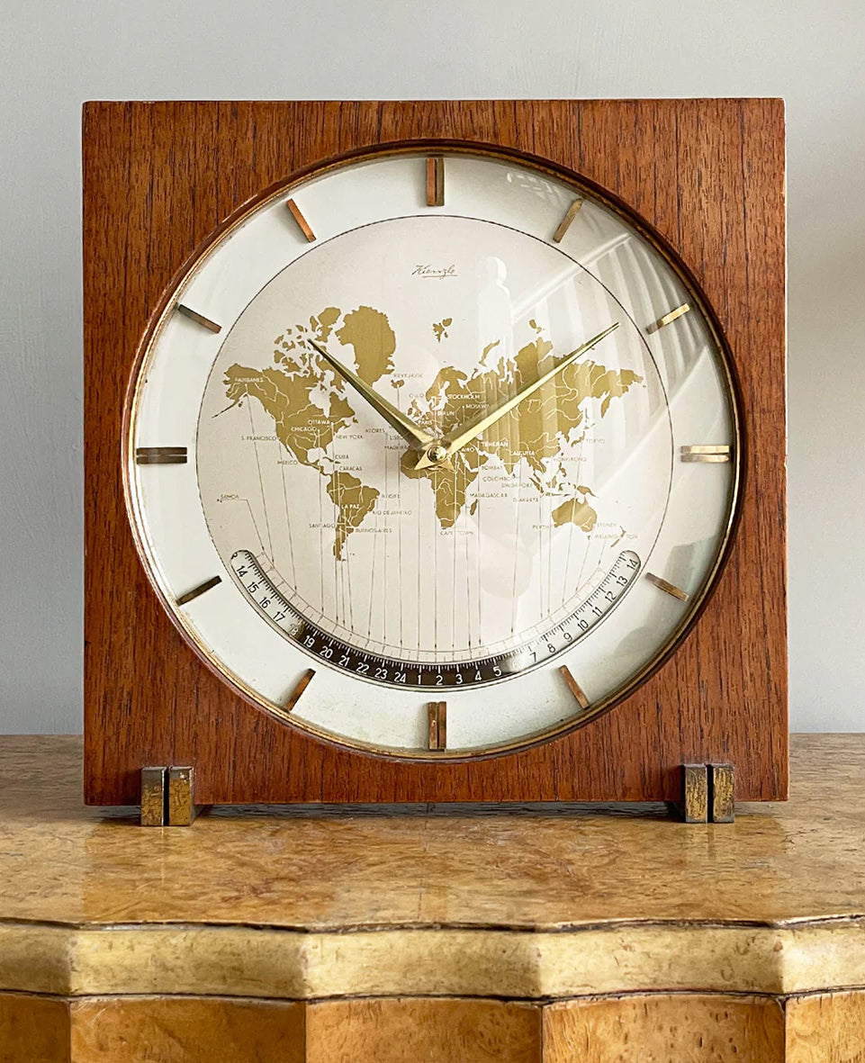 An impressive mid 20th Century World Timer mantel or table clock by Kienzle, Germany with the very rare teak wood surround. The face depicts the countries of the world showing the different time zones - SHOP NOW - www.intovintage.co.uk