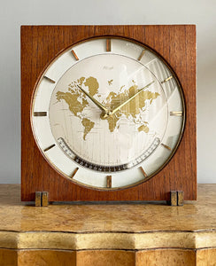 An impressive mid 20th Century World Timer mantel or table clock by Kienzle, Germany with the very rare teak wood surround. The face depicts the countries of the world showing the different time zones - SHOP NOW - www.intovintage.co.uk