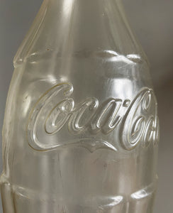 A Very Large Vintage Coke Bottle made from a clear plastic with a red plastic cap lid that has a slot in it so that you can collect your loose change - SHOP NOW - www.intovintage.co.uk