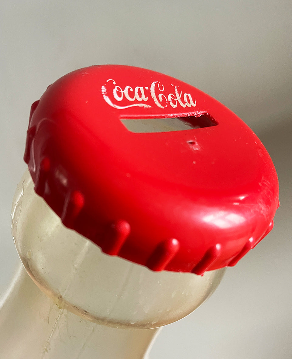 A Very Large Vintage Coke Bottle made from a clear plastic with a red plastic cap lid that has a slot in it so that you can collect your loose change - SHOP NOW - www.intovintage.co.uk