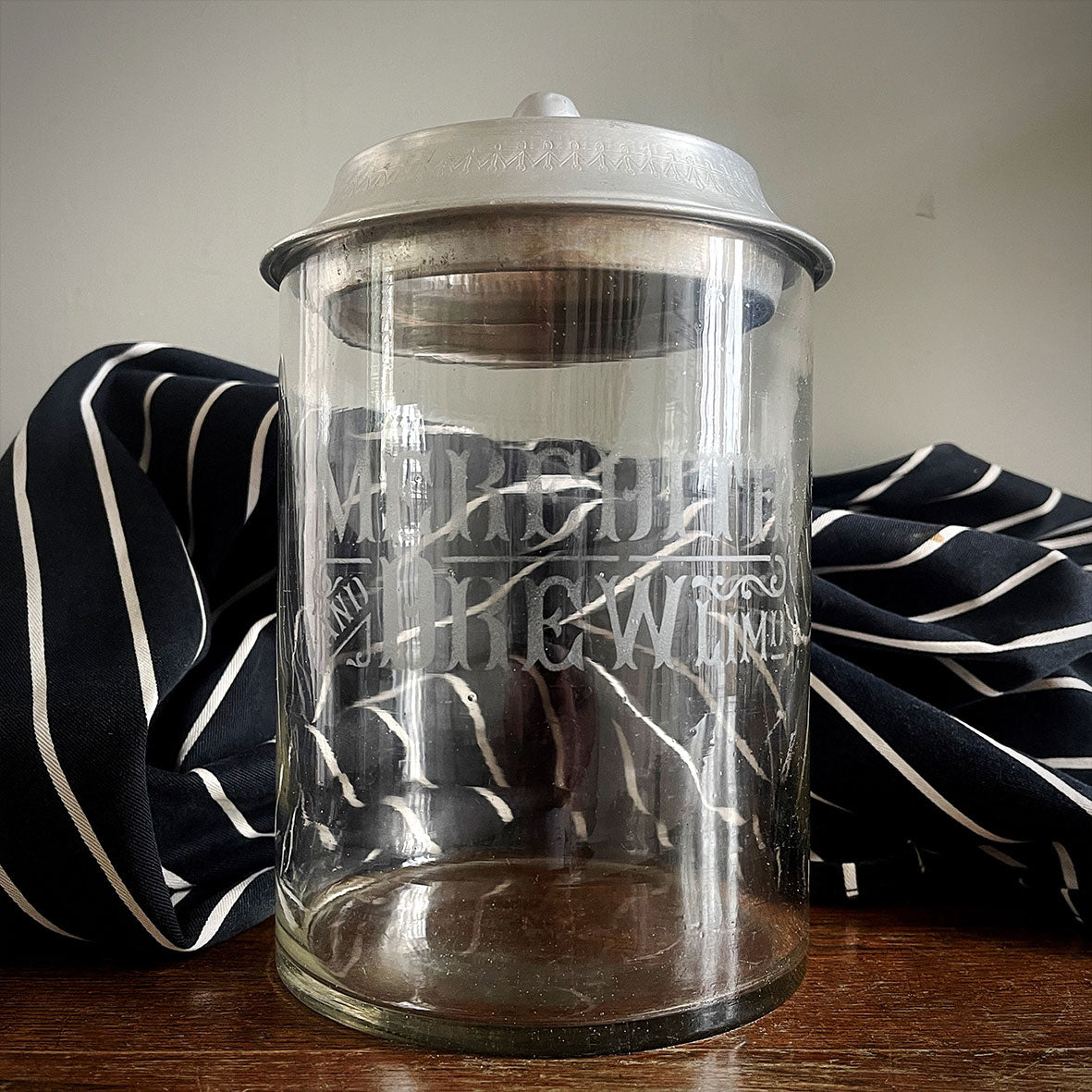 An Edwardian Meredith & Drew Shop Counter Biscuit Jar. Glass body with etched Meredith & Drew Limited logo to the front and an embossed branded lid - SHOP NOW - www.intovintage.co.uk