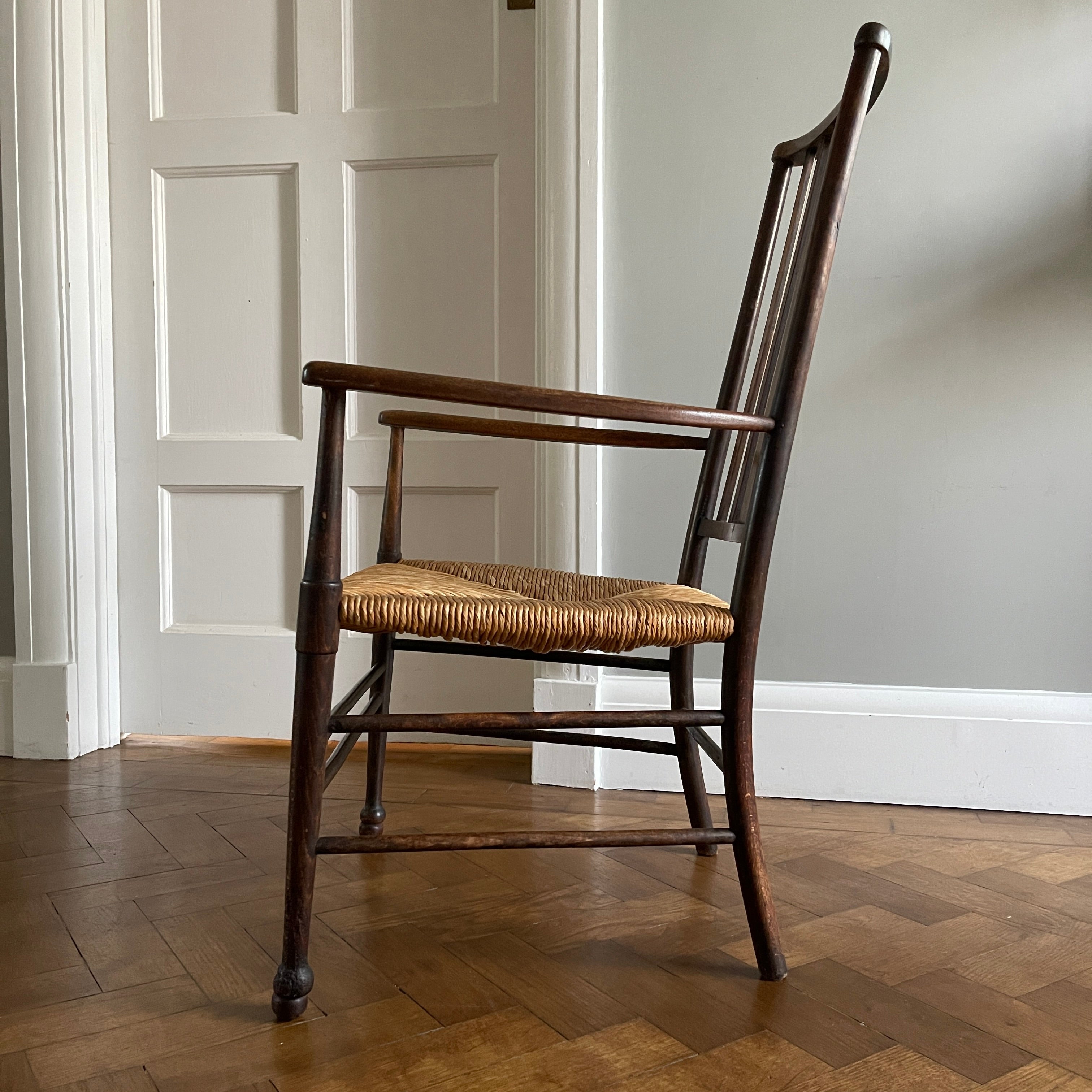 A solid beech Arts and Crafts Chair. Lathe back, rush seat, seven stretchers. Nice patina. A nicely designed and very sturdy chair - SHOP NOW - www.intovintage.co.uk