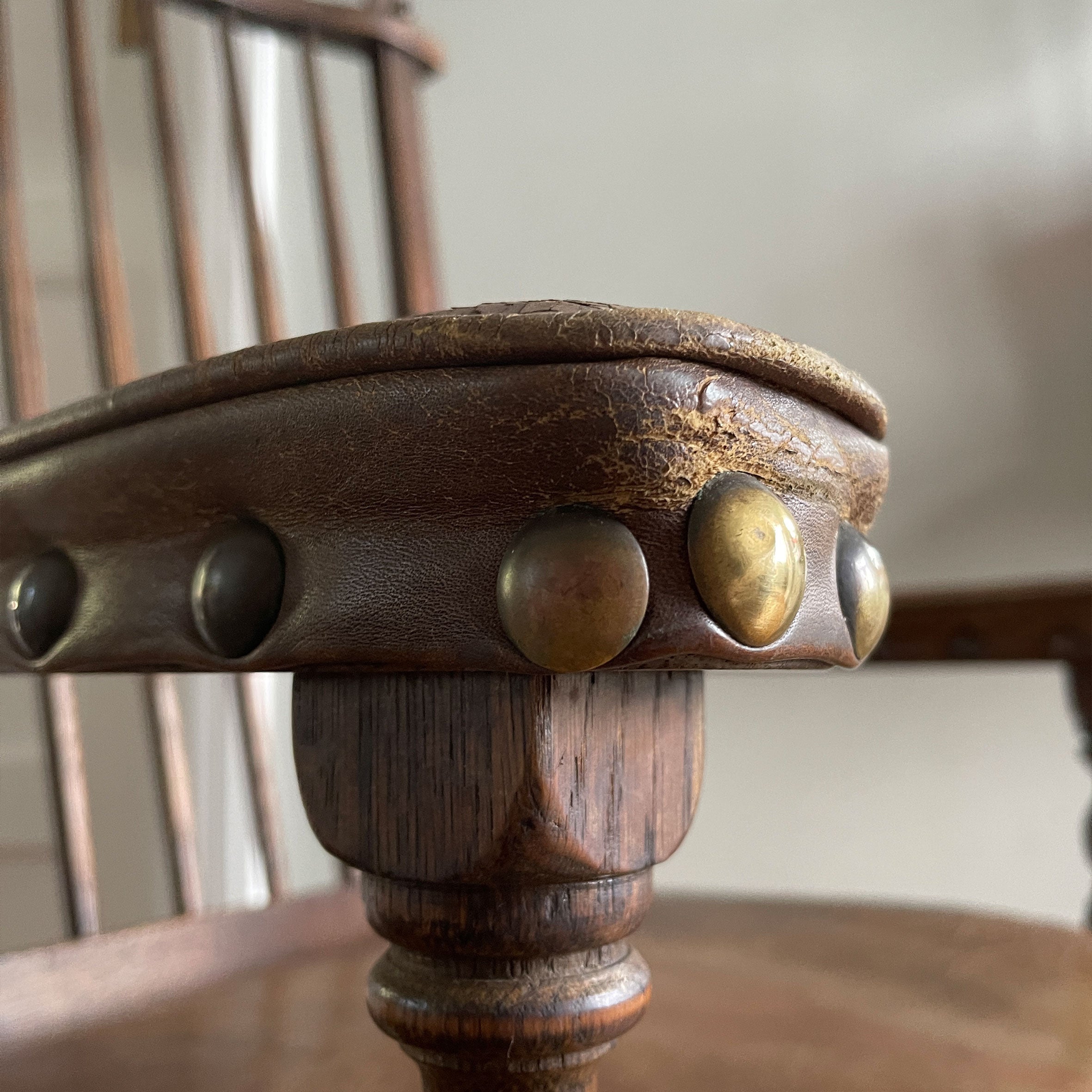 A super solid oak Arts and Crafts styled Carver Chair by the master furniture maker Rupert Griffiths. The style is known as 'Monastic' with this being a Swiss Stick back. The chair has its original leather seat and arms with big old brass studs holding it all in place. The frame is of oak and jointed with oak pegs - SHOP NOW - www.intovintage.co.uk