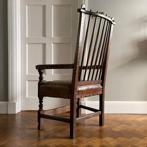 A super solid oak Arts and Crafts styled Carver Chair by the master furniture maker Rupert Griffiths. The style is known as 'Monastic' with this being a Swiss Stick back. The chair has its original leather seat and arms with big old brass studs holding it all in place. The frame is of oak and jointed with oak pegs - SHOP NOW - www.intovintage.co.uk