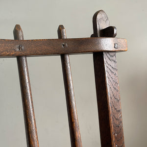 A super solid oak Arts and Crafts styled Carver Chair by the master furniture maker Rupert Griffiths. The style is known as 'Monastic' with this being a Swiss Stick back. The chair has its original leather seat and arms with big old brass studs holding it all in place. The frame is of oak and jointed with oak pegs - SHOP NOW - www.intovintage.co.uk