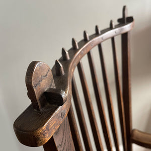 A super solid oak Arts and Crafts styled Carver Chair by the master furniture maker Rupert Griffiths. The style is known as 'Monastic' with this being a Swiss Stick back. The chair has its original leather seat and arms with big old brass studs holding it all in place. The frame is of oak and jointed with oak pegs - SHOP NOW - www.intovintage.co.uk