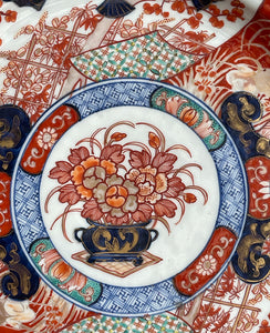 A large Oriental Imari scolloped edged plate with colourful hand painted depictions of Chrysanthemum flowers, fans, birds and cherry blossom. The underside sees a freeze of blue lilies - SHOP NOW - www.intovintage.co.uk
