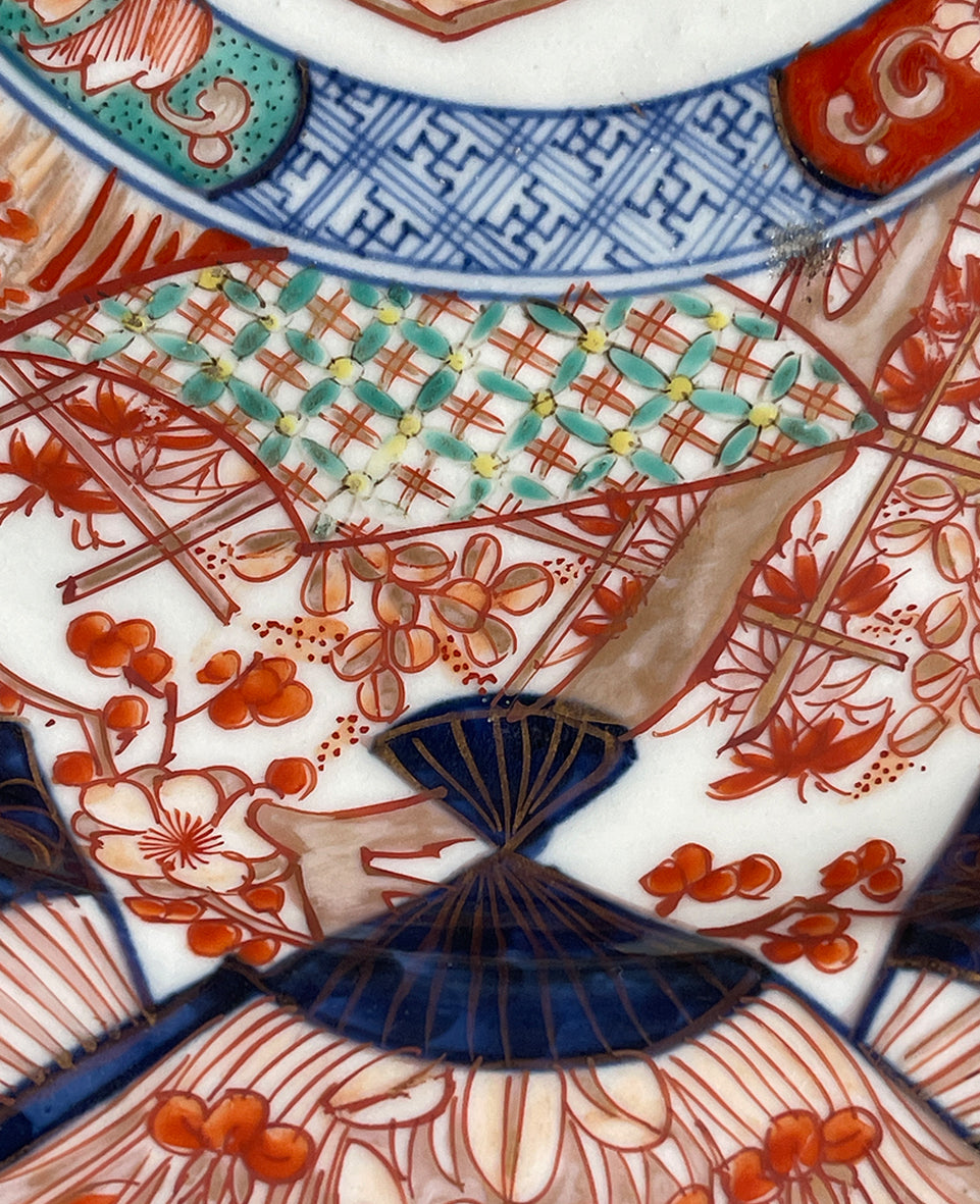 A large Oriental Imari scolloped edged plate with colourful hand painted depictions of Chrysanthemum flowers, fans, birds and cherry blossom. The underside sees a freeze of blue lilies - SHOP NOW - www.intovintage.co.uk