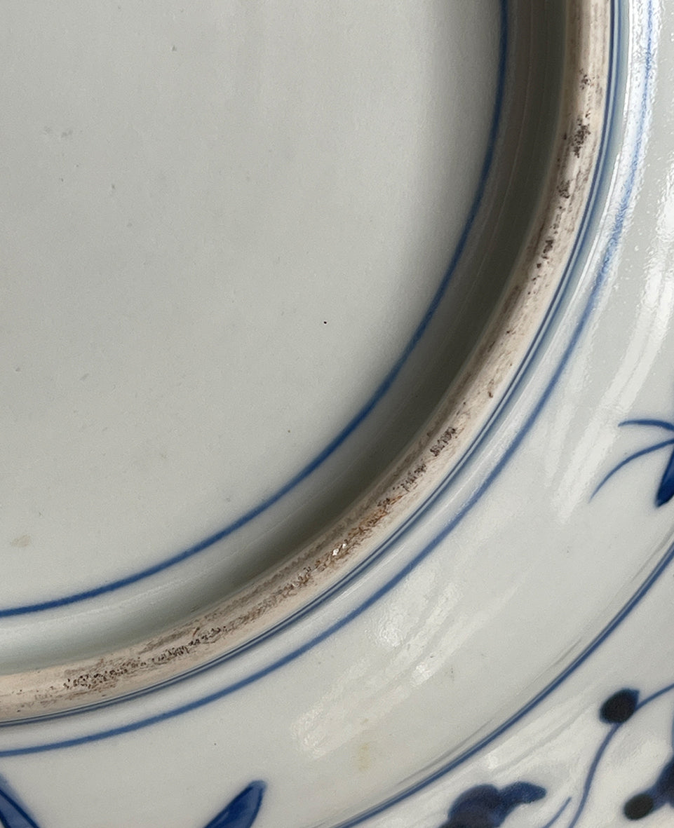 A large Oriental Imari scolloped edged plate with colourful hand painted depictions of Chrysanthemum flowers, fans, birds and cherry blossom. The underside sees a freeze of blue lilies - SHOP NOW - www.intovintage.co.uk