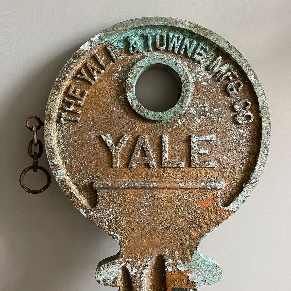 A large cast metal oversized Yale key with its original hanging chains, used as an advertisement display in locksmith shops and ironmongers. It has its original gilt paint finish that has weathered over the yeas to achieve the most amazing patinated finish. Hangs horizontal when suspended on its chains - SHOP NOW - www.intovintage.co.uk