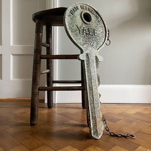 A large cast metal oversized Yale key with its original hanging chains, used as an advertisement display in locksmith shops and ironmongers. It has its original gilt paint finish that has weathered over the yeas to achieve the most amazing patinated finish. Hangs horizontal when suspended on its chains - SHOP NOW - www.intovintage.co.uk