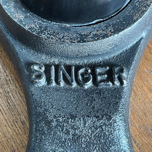An Antique Singer Work Stool. It has a cast iron tripod base with the SINGER brand mark, a black painted steel stem and original turned wooden button seat. The wood shows fantastic age related patina. A great looking stool that would compliment any setting - SHOP NOW - www.intovintage.co.uk