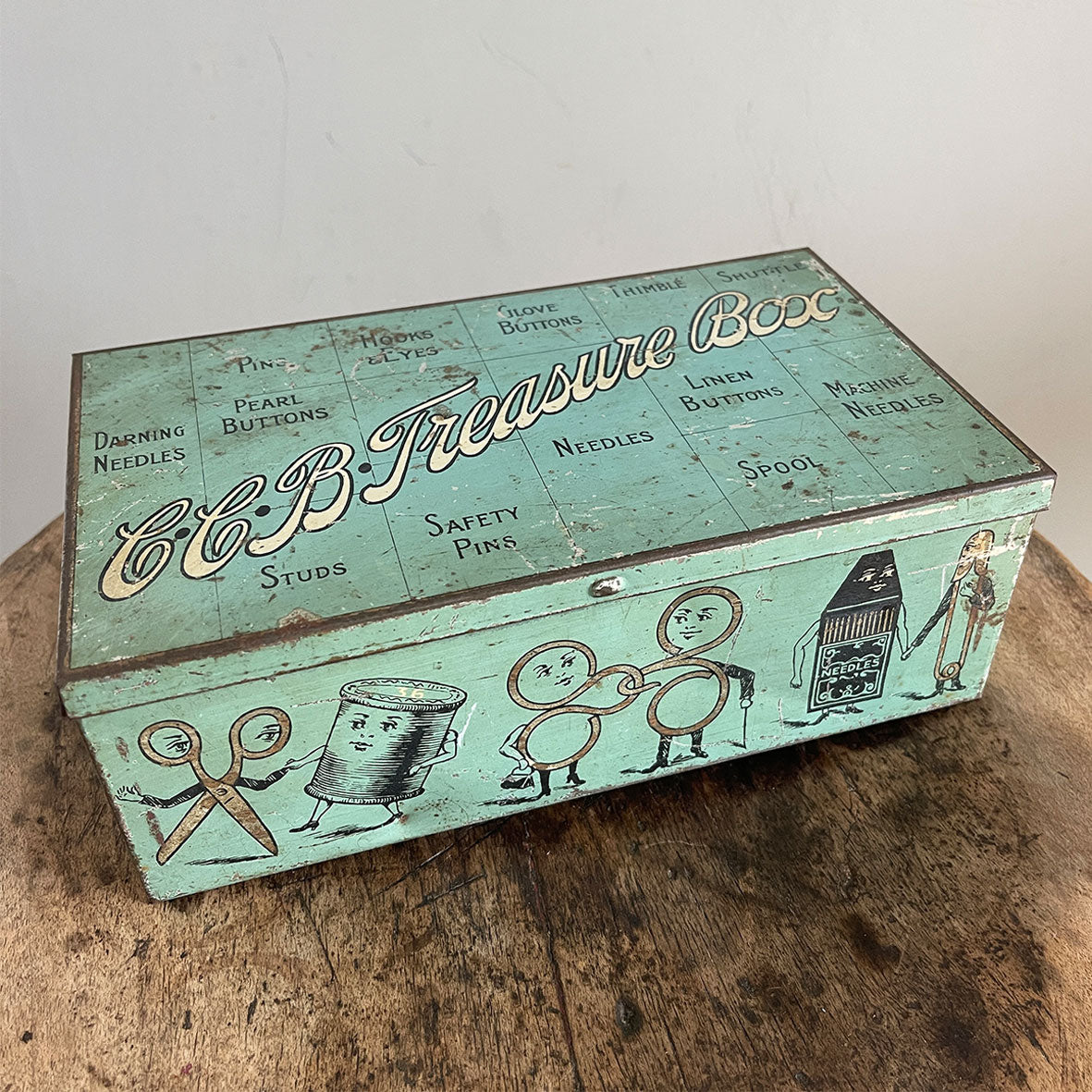 A very whimsical Victorian haberdashery Tin by the Huntley, Boorne & Stevens Company. It has the most fantastic little needlework characters on its sides with the top having the title 'C.C.B. Treasure Box' along with labels for various accessories such as Pearl Buttons, Darning Needles, Studs, Glove Buttons, Hooks &amp; Eyes, and Pearl and Thimbles. The mark 'H.B & Ltd R' appears on the back hinge. - SHOP NOW - www.intovintage.co.uk