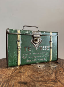 A 'Te Bebe' Buenos Aires Tea Tin in the shape of miniature steamer trunk. It has a little handle on the top lid and each end sees an embossed image of a child carrying a tea box. A rare tin that has travelled all the way from Argentina - SHOP NOW - www.intovintage.co.uk
