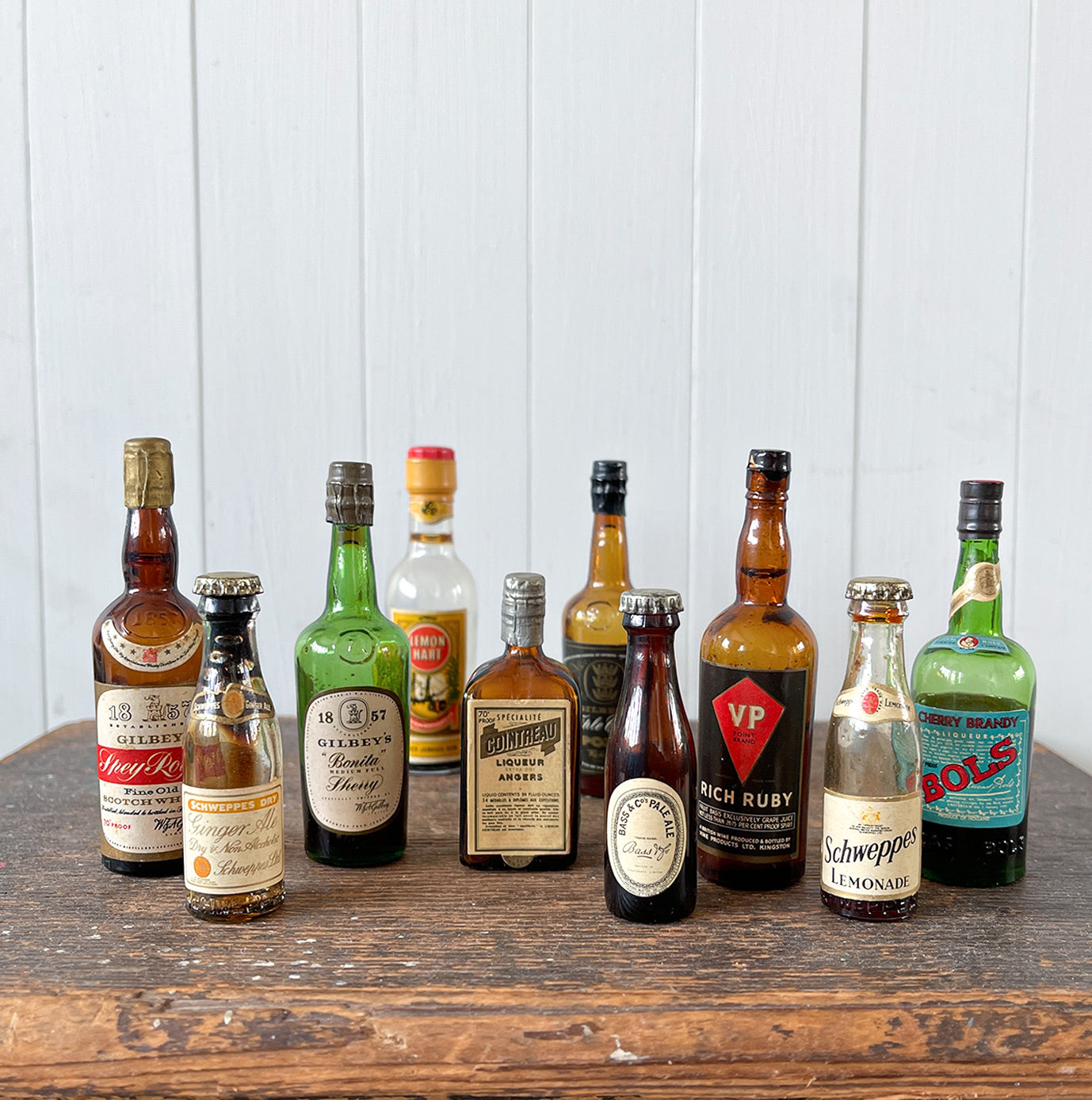 11 mini bottles of vintage Alcohol brands. Not drinkable, but great little display pieces! Brands include Bass, Gilbey's Lemon Heart, Bols, Schweppes and Cointreau - SHOP NOW - www.intovintage.co.uk