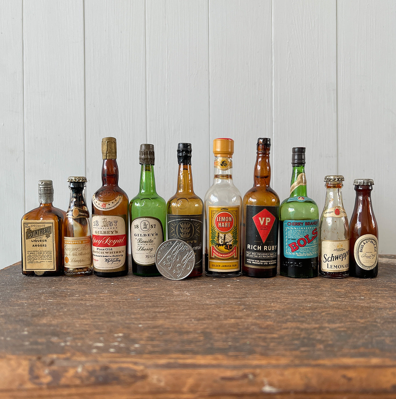 11 mini bottles of vintage Alcohol brands. Not drinkable, but great little display pieces! Brands include Bass, Gilbey's Lemon Heart, Bols, Schweppes and Cointreau - SHOP NOW - www.intovintage.co.uk