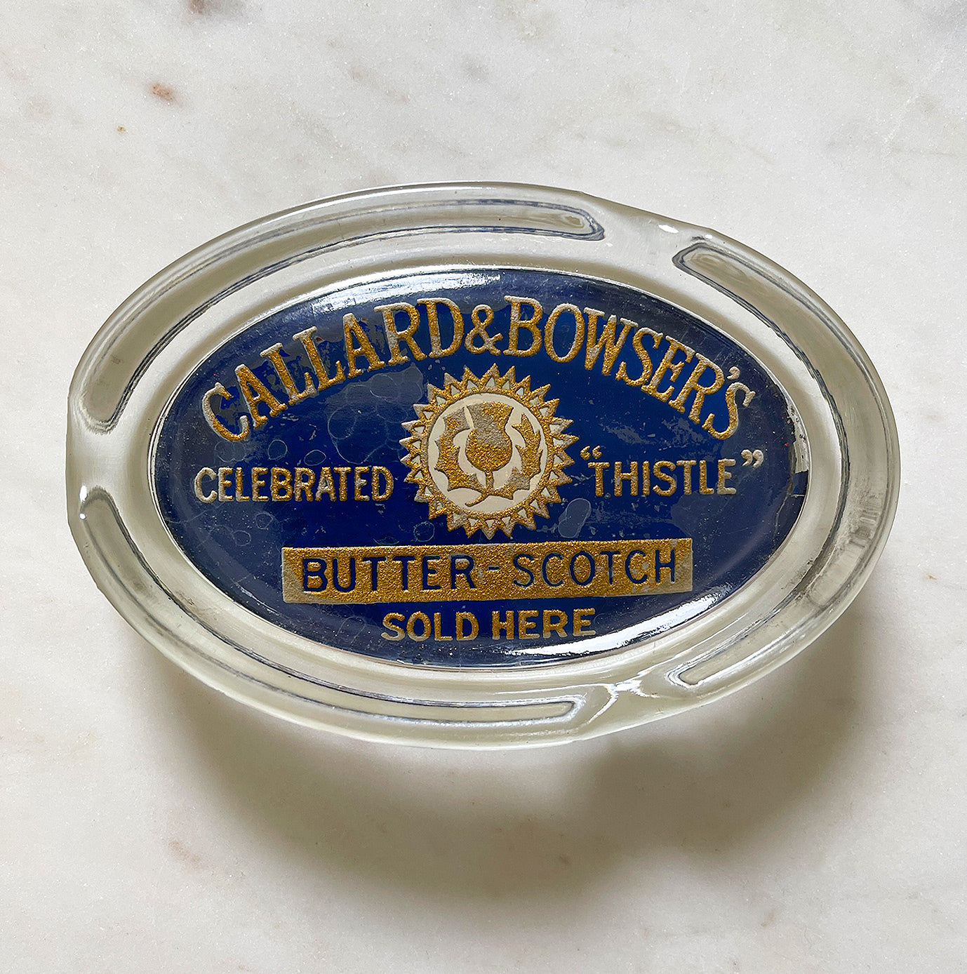 A Glass Callard & Bowser's Celebrated Thistle Butter Scotch Advertising Ashtray with nice gold and blue typography and thistle graphic - SHOP NOW - www.intovintage.co.uk