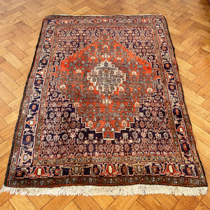 A beautiful, rich dark blue and red handmade Persian Heriz rug in wool. The overall condition is very good. With one pale blue central medallion decoration on a red diamond background framed by deep blue. A good practical size - SIZE: (L) 150cm   (W) 115cm - SHOP NOW www.intovintage.co.uk
