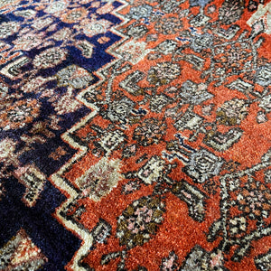 A beautiful, rich dark blue and red handmade Persian Heriz rug in wool. The overall condition is very good. With one pale blue central medallion decoration on a red diamond background framed by deep blue. A good practical size - SIZE: (L) 150cm   (W) 115cm - SHOP NOW www.intovintage.co.uk