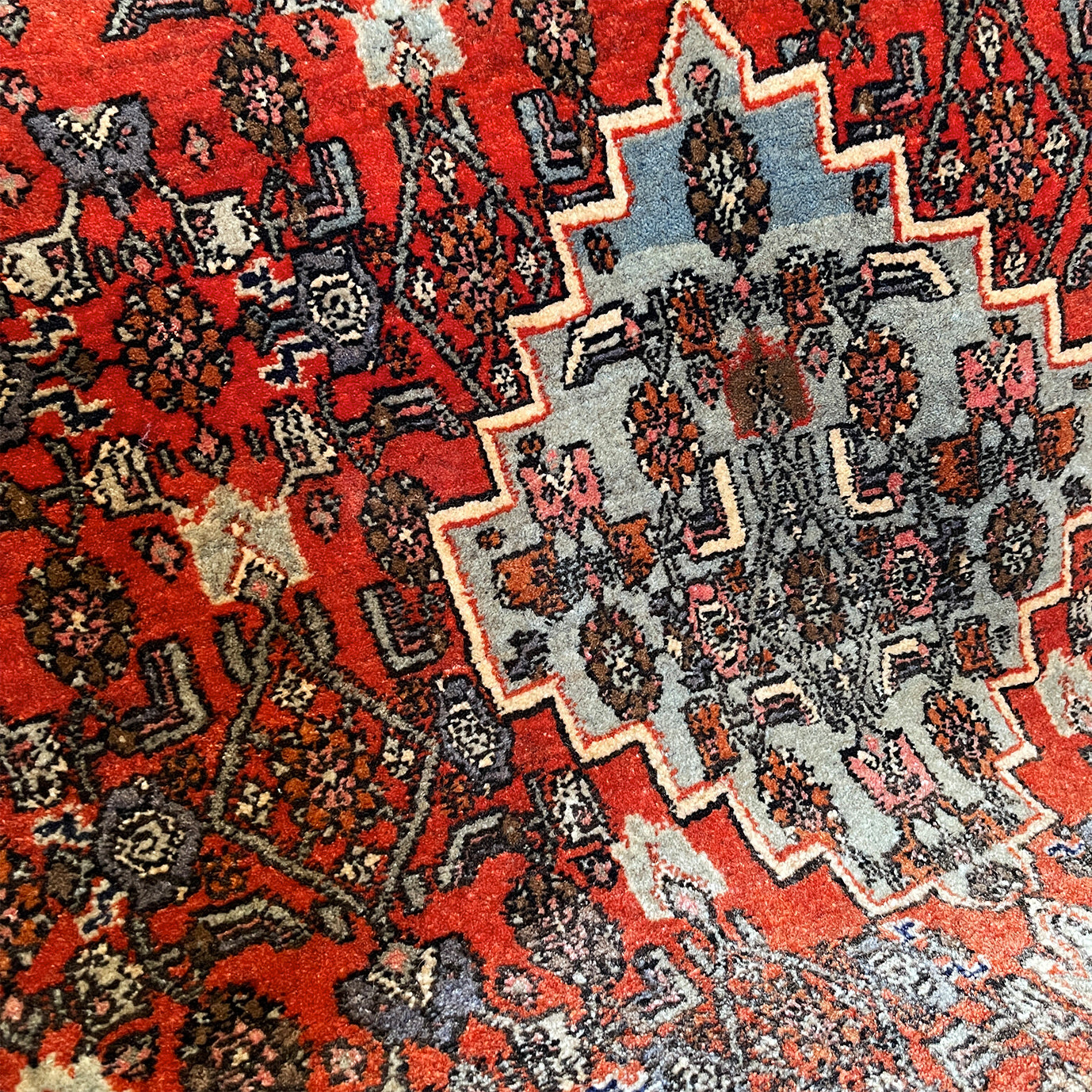 A beautiful, rich dark blue and red handmade Persian Heriz rug in wool. The overall condition is very good. With one pale blue central medallion decoration on a red diamond background framed by deep blue. A good practical size - SIZE: (L) 150cm   (W) 115cm - SHOP NOW www.intovintage.co.uk