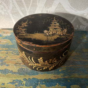 A delightful Oriental wooden Trinket box with lid. Decorated with a Pagoda scene to the lid, with the side having a floral fern decoration. The inside sees a brick red finish with flecks of gold. Great wear to the black paint around the edges on the outside - SHOP NOW - www.intovintage.co.uk
