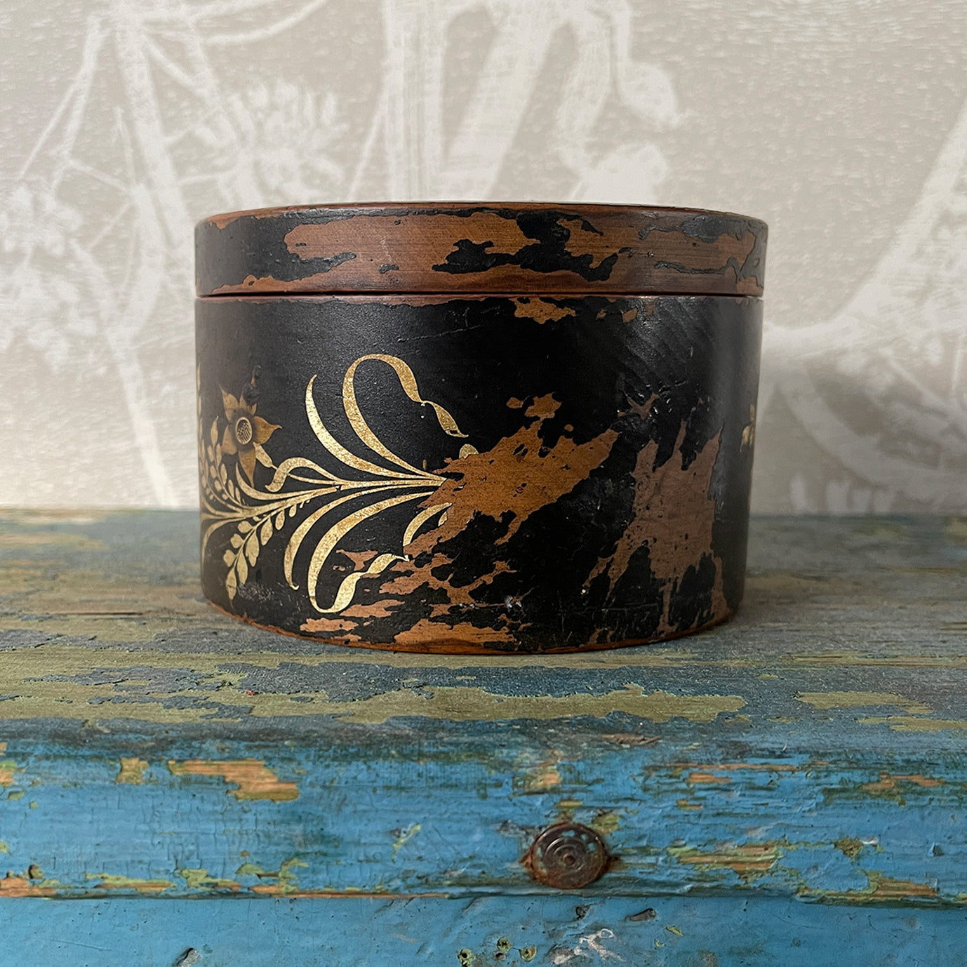 A delightful Oriental wooden Trinket box with lid. Decorated with a Pagoda scene to the lid, with the side having a floral fern decoration. The inside sees a brick red finish with flecks of gold. Great wear to the black paint around the edges on the outside - SHOP NOW - www.intovintage.co.uk