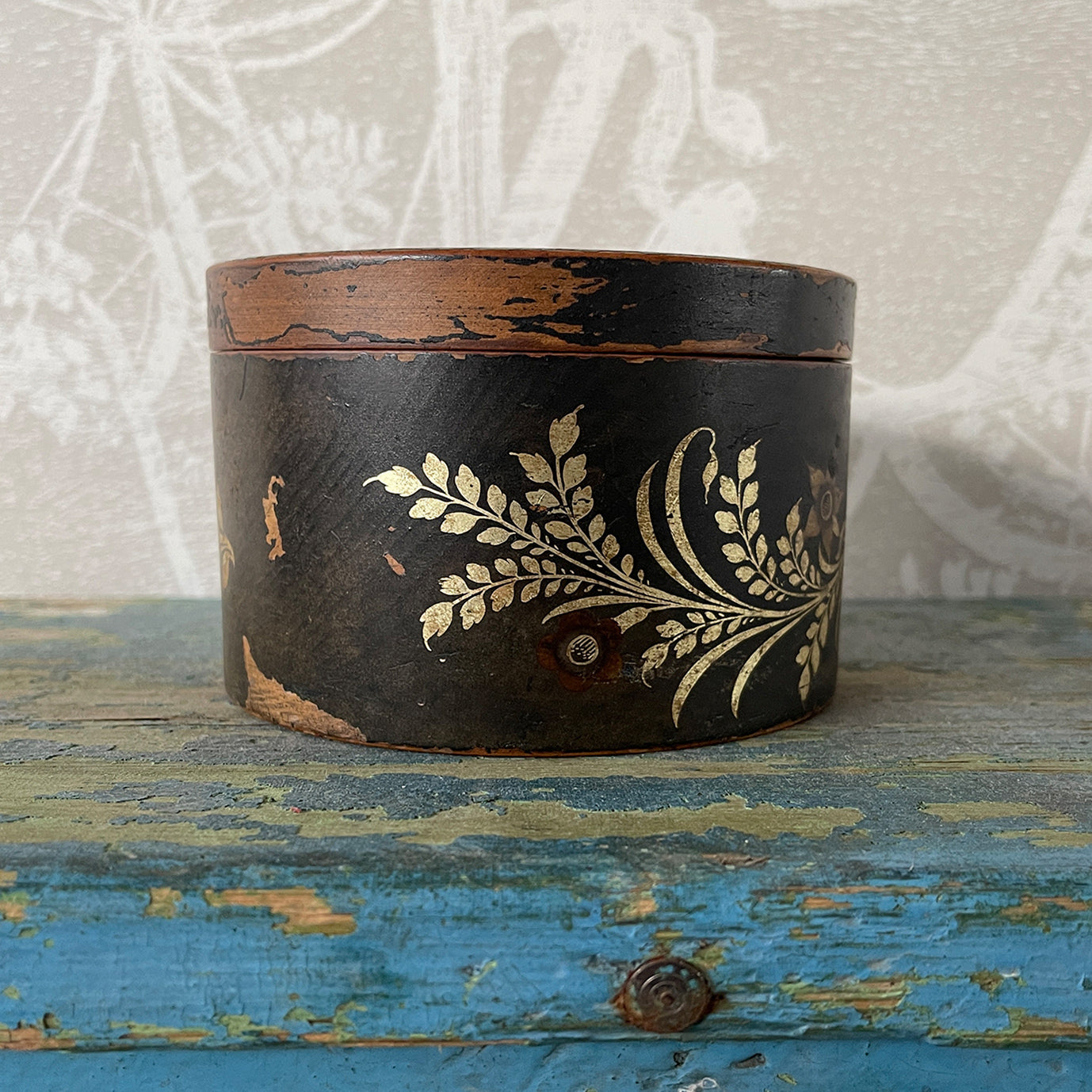 A delightful Oriental wooden Trinket box with lid. Decorated with a Pagoda scene to the lid, with the side having a floral fern decoration. The inside sees a brick red finish with flecks of gold. Great wear to the black paint around the edges on the outside - SHOP NOW - www.intovintage.co.uk
