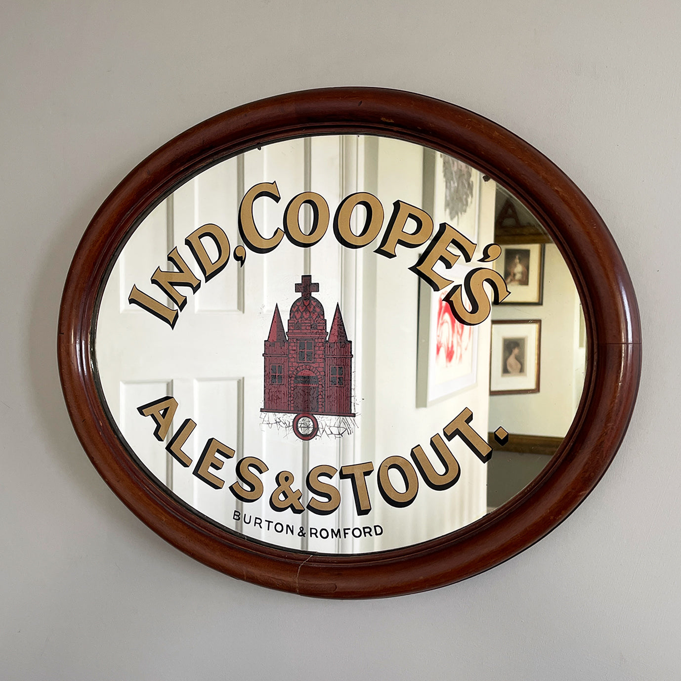 An Original Ind Coope's Pub Mirror with great foxing around the central red church. It has a rounded mahogany frame with the 'Ind Coope & Co Ltd' stamp in. A fine example of brewery advertising - SHOP NOW - www.intovintage.co.uk