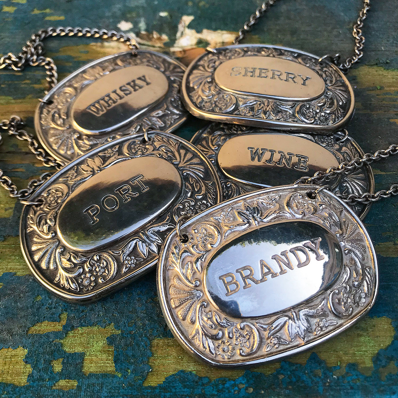 Nice set of 5 silver plated Decanter Markers. Each of the Whisky, Sherry, Port, Brandy and Wine name plates have a embossed floral border and have good unblemished silver plate, they also all have their original chains. A nice little set for the drinks trolly - SHOP NOW - www.intovintage.co.uk