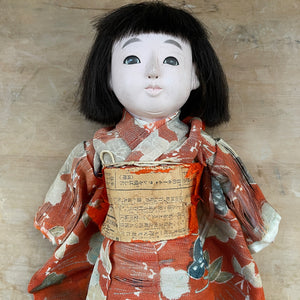 A beautiful time worn Japanese Ichimatsu doll crafted in Kyoto, circa 1930. Dressed in a faded and worn red silk kimono. She has glass eyes, articulated limbs and squeaks when you press her tummy. Her black straight hair is cut and combed in the fashion of Taisho era (1912-1924 - SHOP NOW - www.intovintage.co.uk