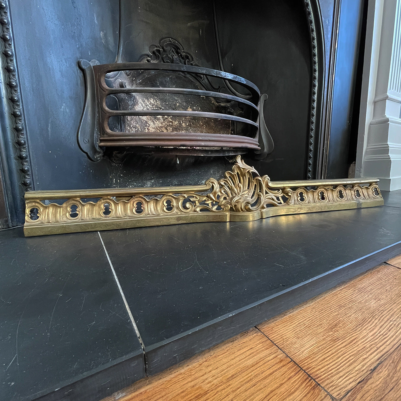 Victorian Gilded Cast Brass Fireplace Ash Keep with Its Rococo styling adding a touch of grandeur to any fireplace. It sits across the floor of the hearth below the basket stopping the ash spill out over the front of the fireplace. Good looking and practical too - SHOP NOW - www.intovintage.co.uk
