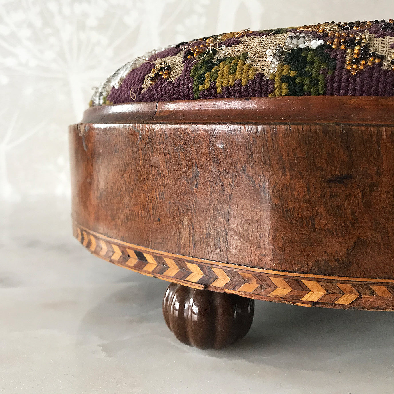 Pretty pair of Edwardian Foot Stools. Veneered mahogany bases with a chevron detail and ceramic feet. The tops are finished in a nicely coloured flower and leaf tapestry material with sewn in beadwork - SHOP NOW - www.intovintage.co.uk
