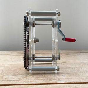 A Vintage Mechanical Teaching Aid that shows the mechanics of chained gears. Turning the little handle rotates a cog connected to a mini chain that in turn, turns another larger cog which rotates a green arrow - SHOP NOW - www.intovintage.co.uk