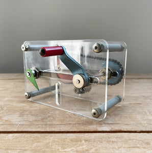 A Vintage Mechanical Teaching Aid that shows the mechanics of chained gears. Turning the little handle rotates a cog connected to a mini chain that in turn, turns another larger cog which rotates a green arrow - SHOP NOW - www.intovintage.co.uk