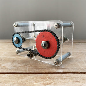 A Vintage Mechanical Teaching Aid that shows the mechanics of chained gears. Turning the little handle rotates a cog connected to a mini chain that in turn, turns another larger cog which rotates a green arrow - SHOP NOW - www.intovintage.co.uk