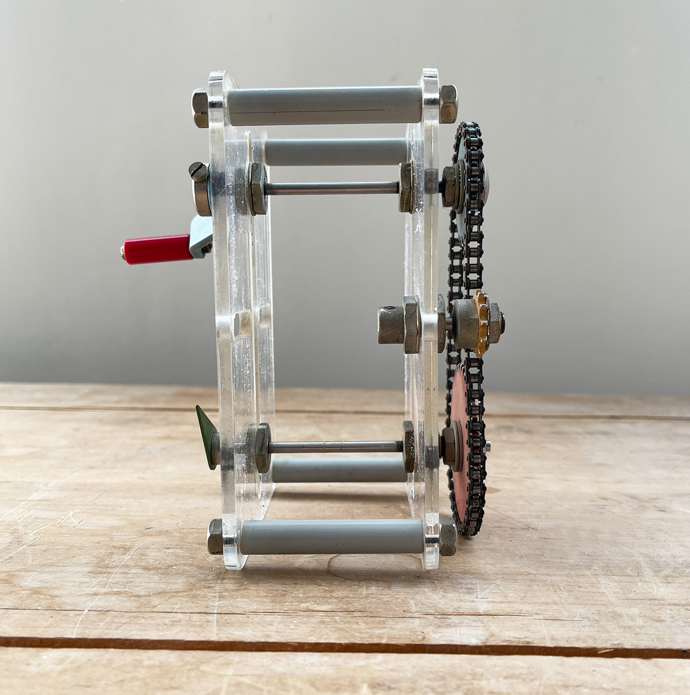 A Vintage Mechanical Teaching Aid that shows the mechanics of chained gears. Turning the little handle rotates a cog connected to a mini chain that in turn, turns another larger cog which rotates a green arrow - SHOP NOW - www.intovintage.co.uk